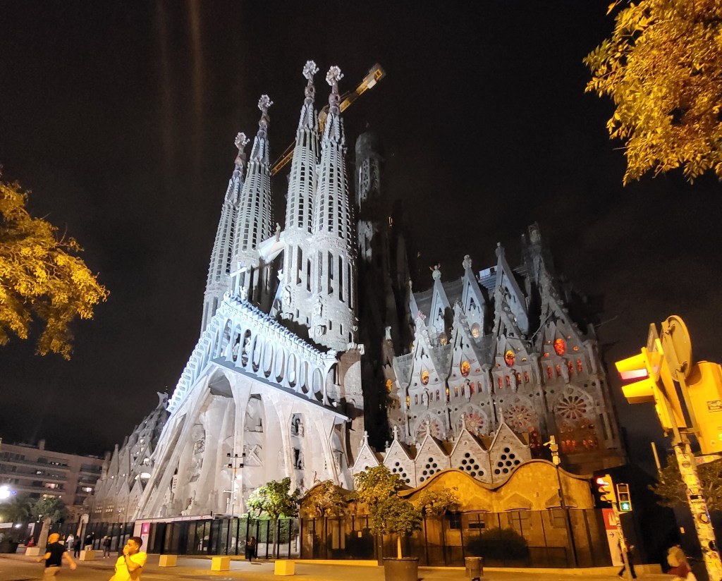 The stunning Sagrada Familia church in Barcelona, illuminated against the night sky.