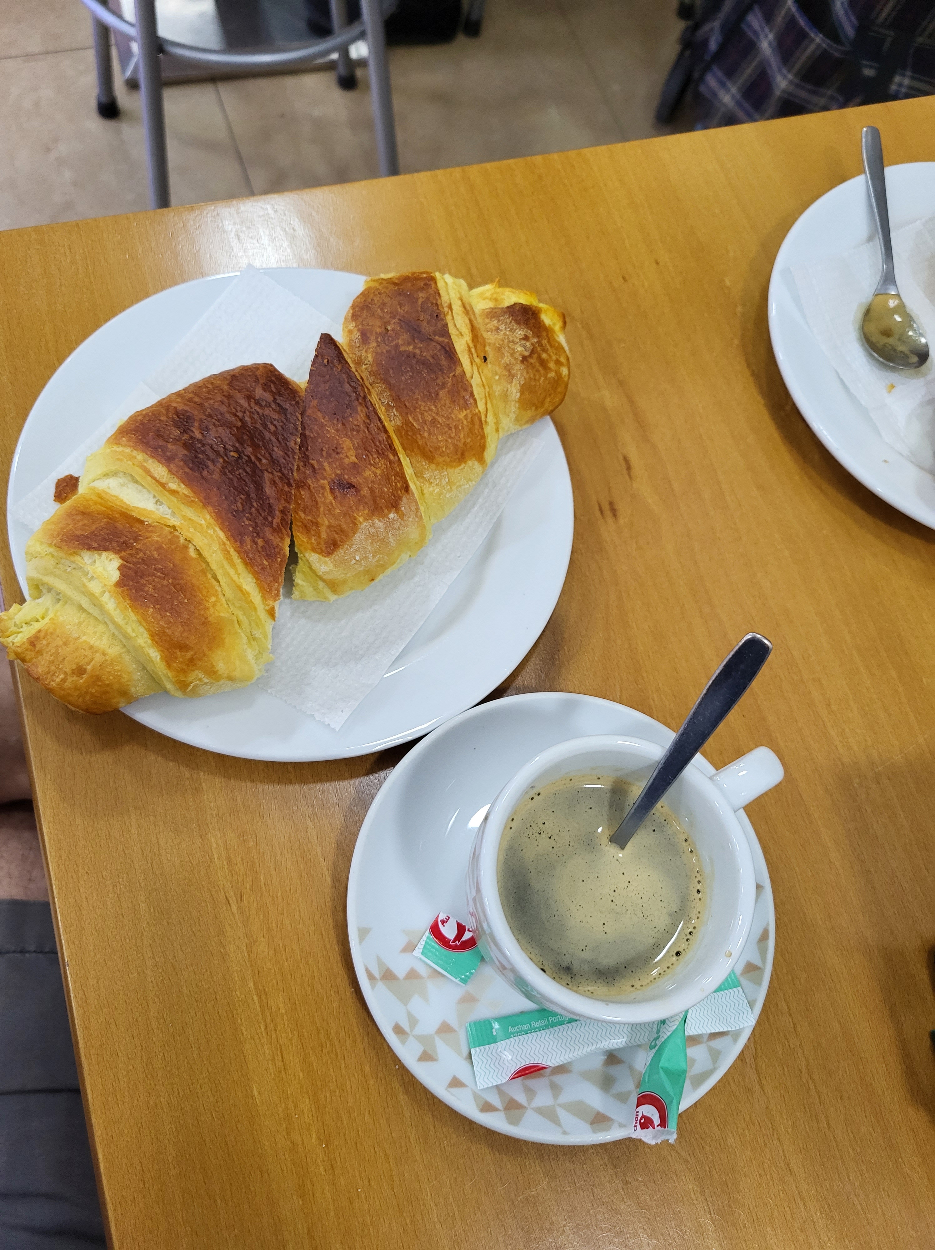 A croissant and a cup of coffee sit on the tabletop. The croissant was the best one ever made and the coffee a fine companion to the pastry!