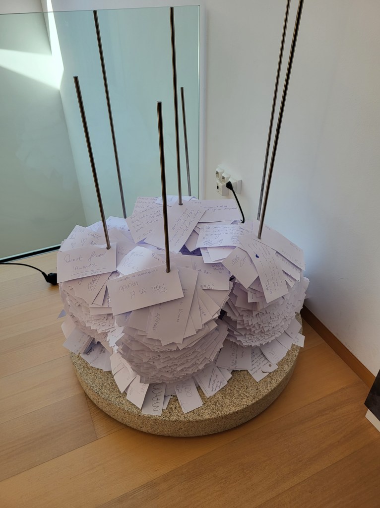 These pieces of paper are stacked on vertical metal rods. Each paper has a prayer or desire of those that have visited the Museum of Pilgrimages. It is symbolic of the mound of rock at the Cruz de Ferro on the Camino Frances.