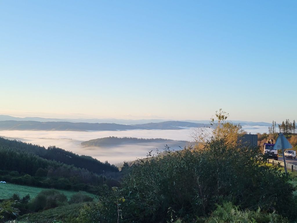 A view of the foggy valleys from the hills on the outskirts of a Spanish village.