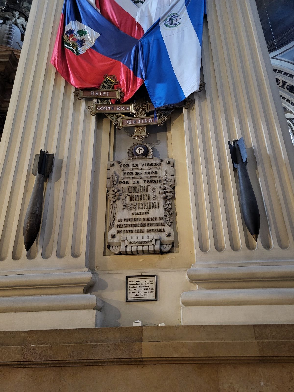 Two undetonated bombs hanging on a wall.